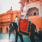Tourists enjoying an elephant ride at Amber Fort in Jaipur, capturing vibrant Indian architecture and culture.